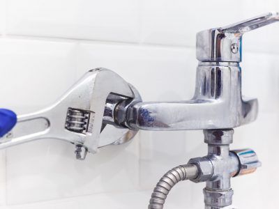 Plumber uses pipe wrench for service shower mixer tap.